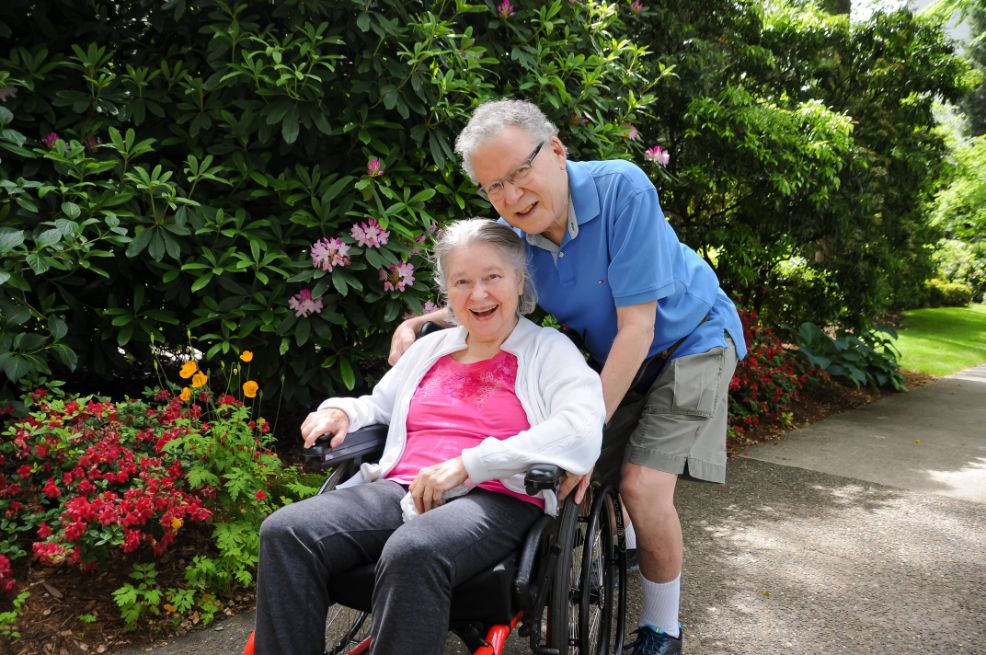 Elderly couple with lady in wheelchair smiling at camera in Shaughnessy