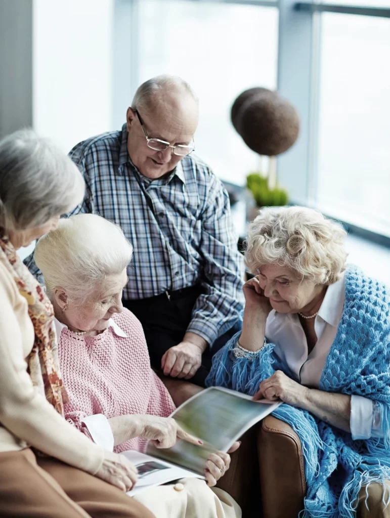 Group of friendly seniors looking through magazine